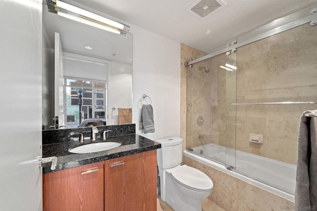 full bathroom with tile patterned flooring, vanity, toilet, and combined bath / shower with glass door