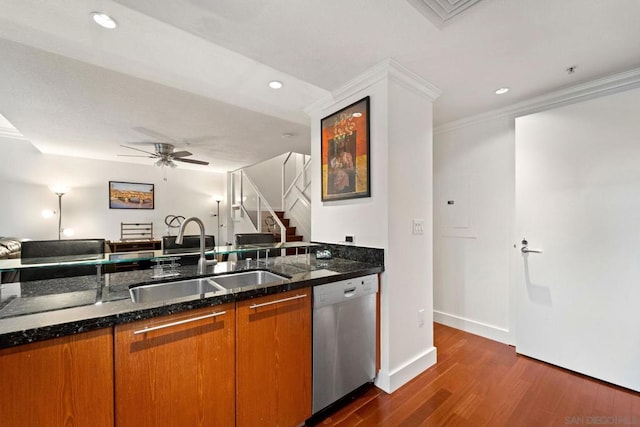 kitchen with dishwasher, dark stone counters, crown molding, sink, and dark hardwood / wood-style floors