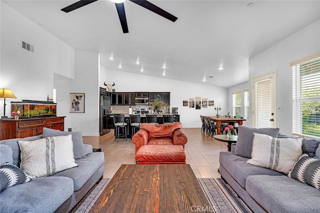 tiled living room featuring ceiling fan and vaulted ceiling