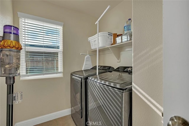 clothes washing area featuring washing machine and dryer and light tile patterned floors