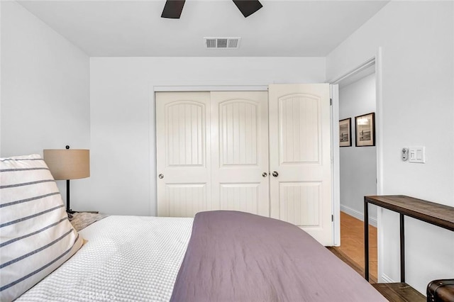 bedroom with ceiling fan, wood-type flooring, and a closet