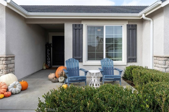 view of exterior entry with a patio