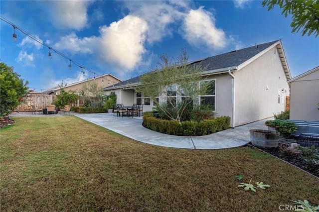 rear view of house with a yard and a patio area