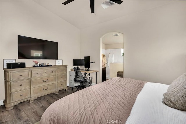 bedroom with vaulted ceiling, connected bathroom, ceiling fan, and dark hardwood / wood-style floors