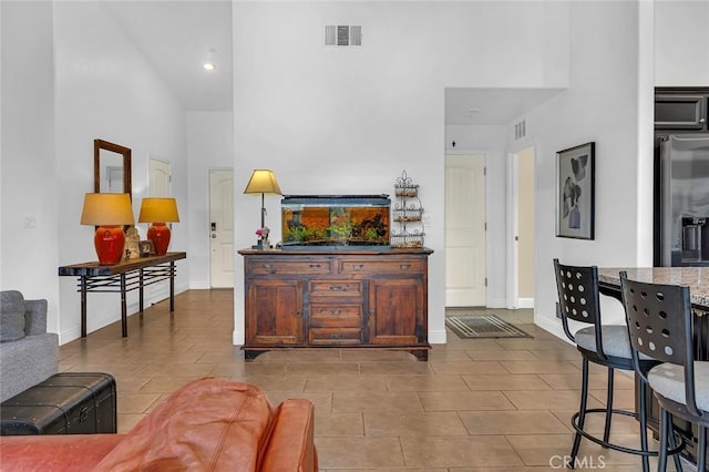 living room featuring a towering ceiling and light tile patterned flooring