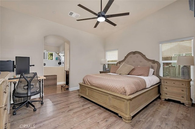 bedroom with lofted ceiling, multiple windows, and light hardwood / wood-style flooring