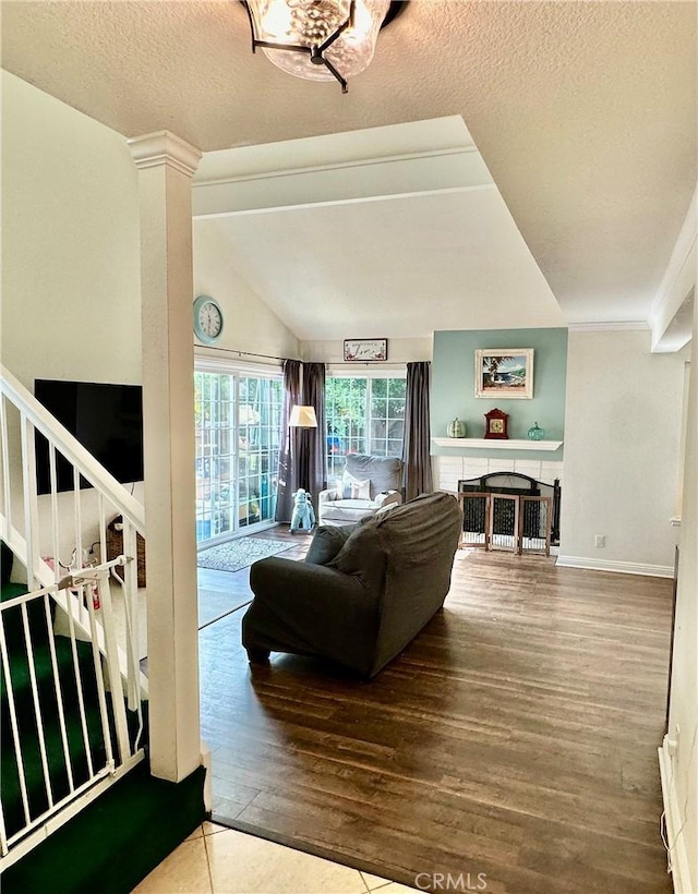 living room featuring a textured ceiling, lofted ceiling, and hardwood / wood-style flooring