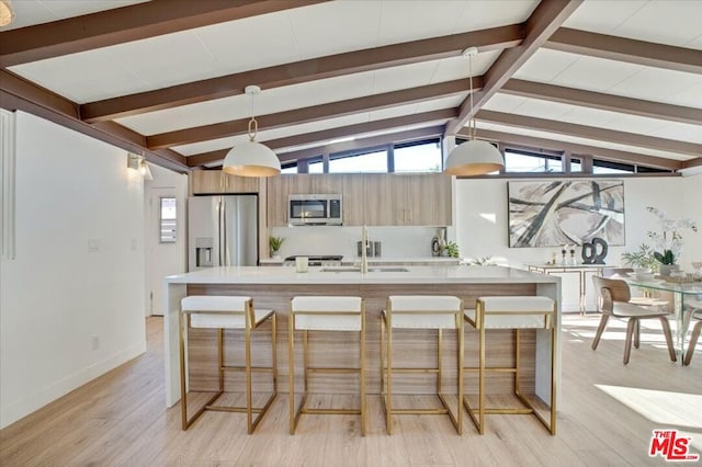 kitchen featuring a kitchen bar, appliances with stainless steel finishes, vaulted ceiling with beams, and pendant lighting