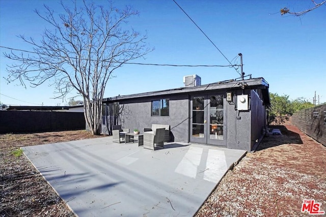 rear view of property with an outdoor living space and a patio