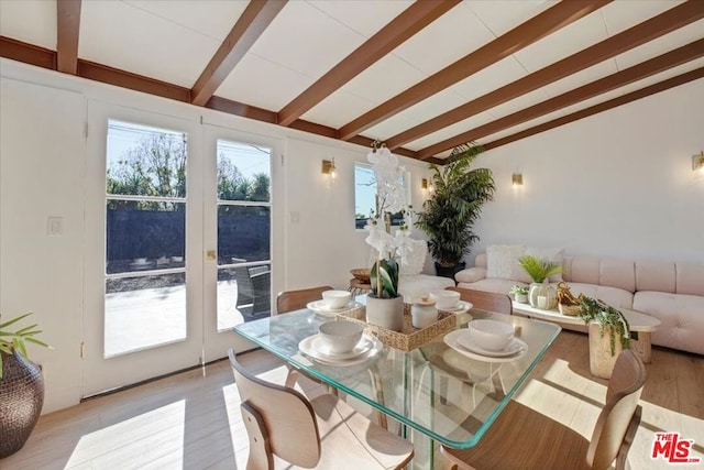 sunroom featuring vaulted ceiling with beams