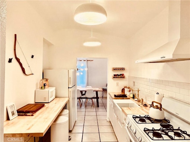 kitchen featuring tasteful backsplash, light countertops, white cabinets, white appliances, and wall chimney exhaust hood