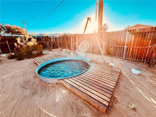 view of pool featuring a fenced backyard and a hot tub