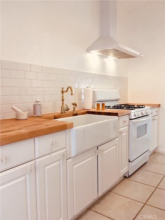 kitchen featuring white range with gas stovetop, a sink, white cabinets, wooden counters, and ventilation hood