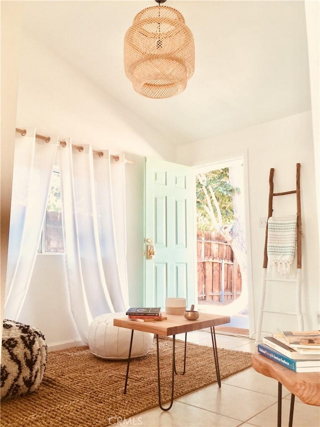 living area featuring lofted ceiling and light tile patterned flooring