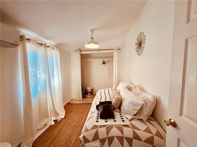 bedroom with a closet and a wall mounted air conditioner