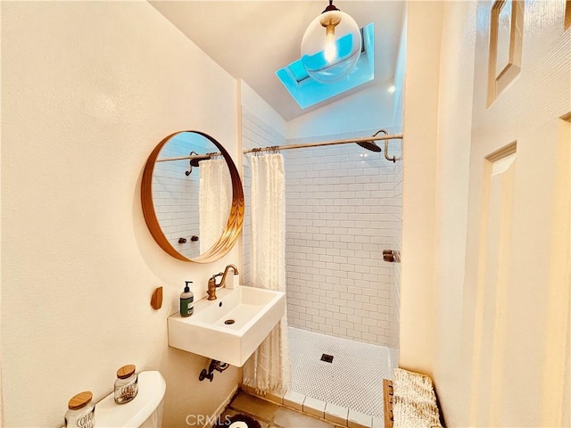 full bath with a sink, a tile shower, and toilet