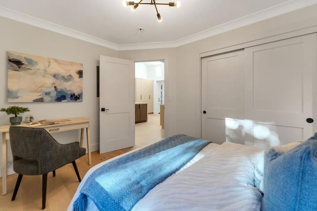 bedroom with an inviting chandelier, ornamental molding, a closet, and light wood-type flooring