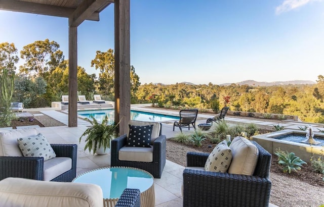 view of patio / terrace featuring a mountain view and a pool with hot tub