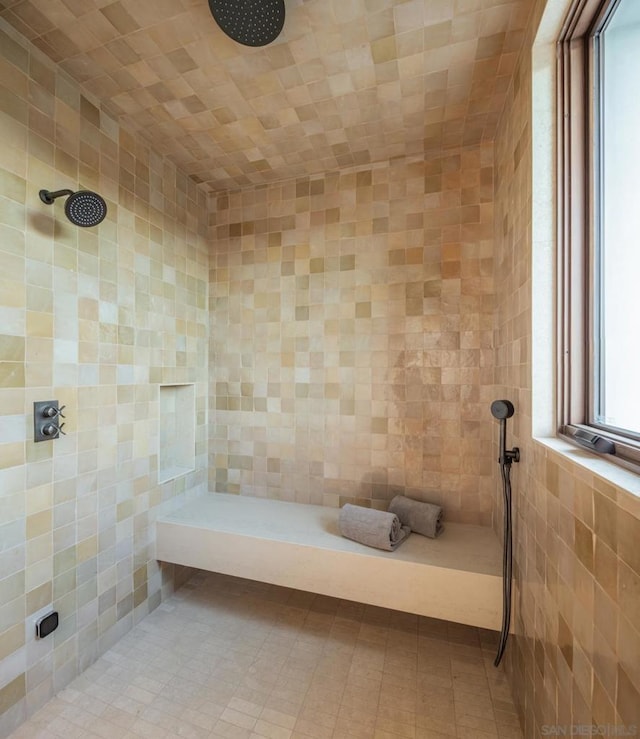 bathroom with tiled shower and tile walls