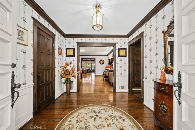 entryway with dark hardwood / wood-style flooring and crown molding