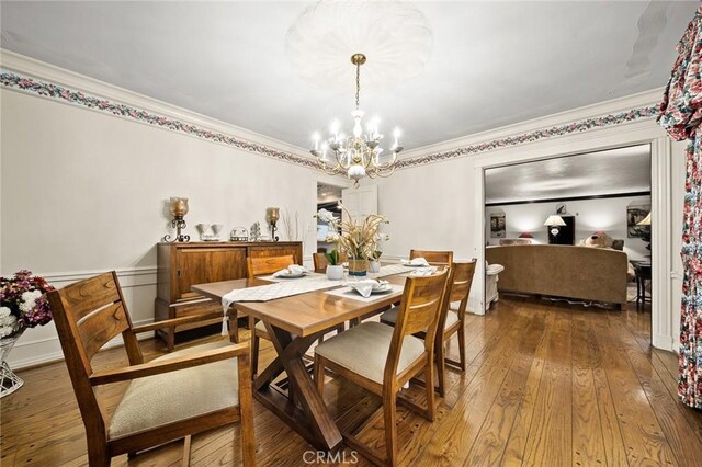 dining area featuring a chandelier, hardwood / wood-style flooring, and crown molding