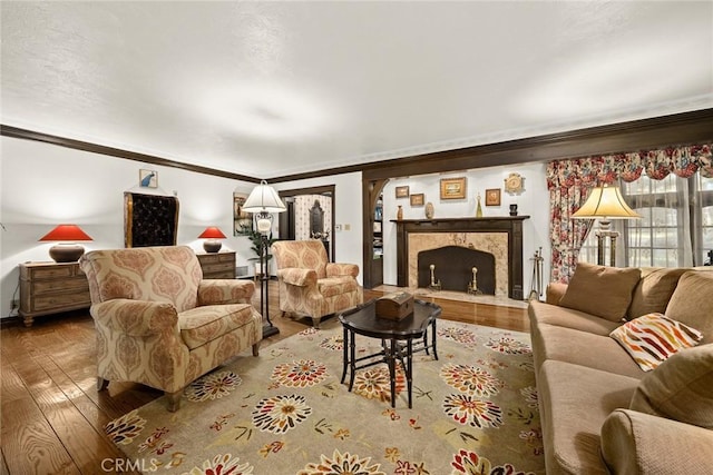 living room with a fireplace, crown molding, and hardwood / wood-style floors