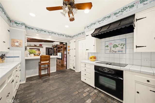 kitchen with white cabinets, tasteful backsplash, and black appliances