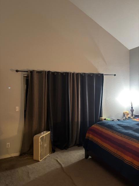 bedroom featuring lofted ceiling and dark carpet