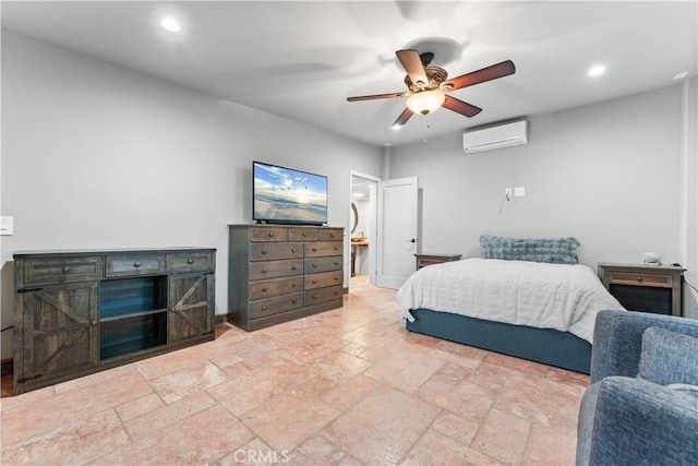 bedroom with ceiling fan, a wall unit AC, and connected bathroom