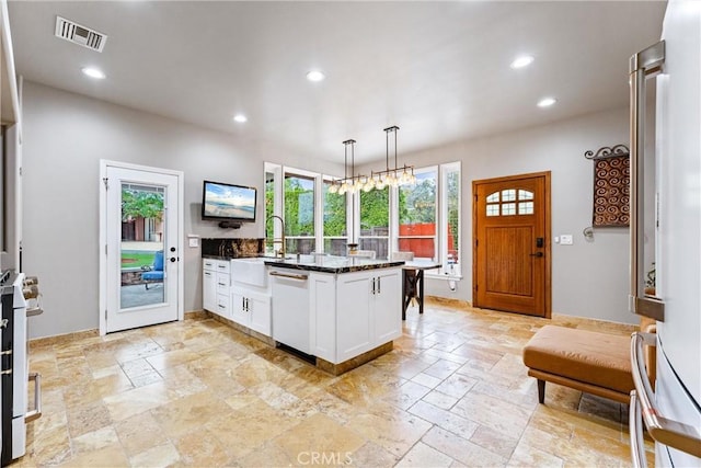 kitchen featuring white cabinetry, hanging light fixtures, dark stone countertops, kitchen peninsula, and white appliances