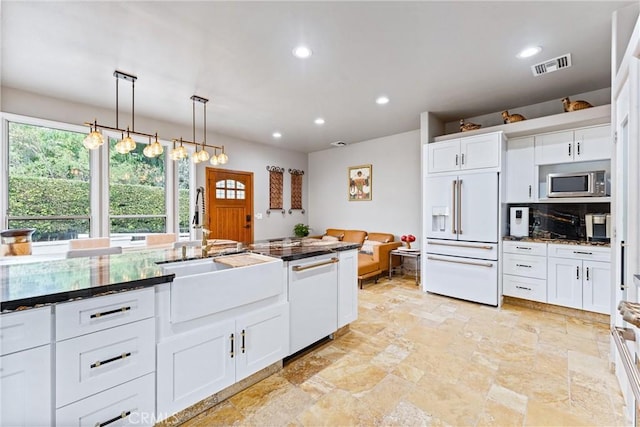 kitchen with white cabinets, white appliances, decorative light fixtures, and sink