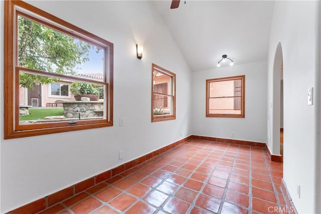 unfurnished room with tile patterned flooring, vaulted ceiling, and ceiling fan