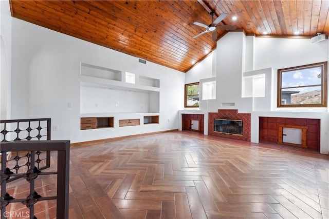 living room with a tile fireplace, wooden ceiling, built in features, high vaulted ceiling, and parquet flooring