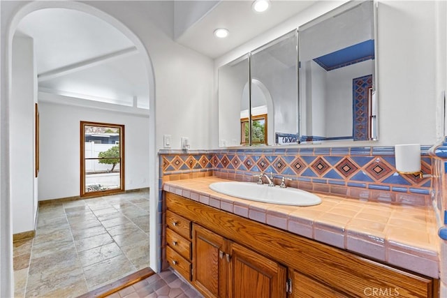 bathroom featuring vanity and backsplash