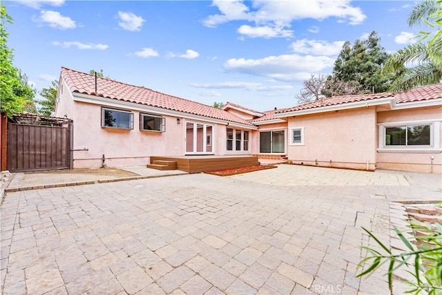 11431 Clybourn Ave, Lakeview Terrace, CA 91342 - back of property with a patio area, a tiled roof, a gate, and stucco siding