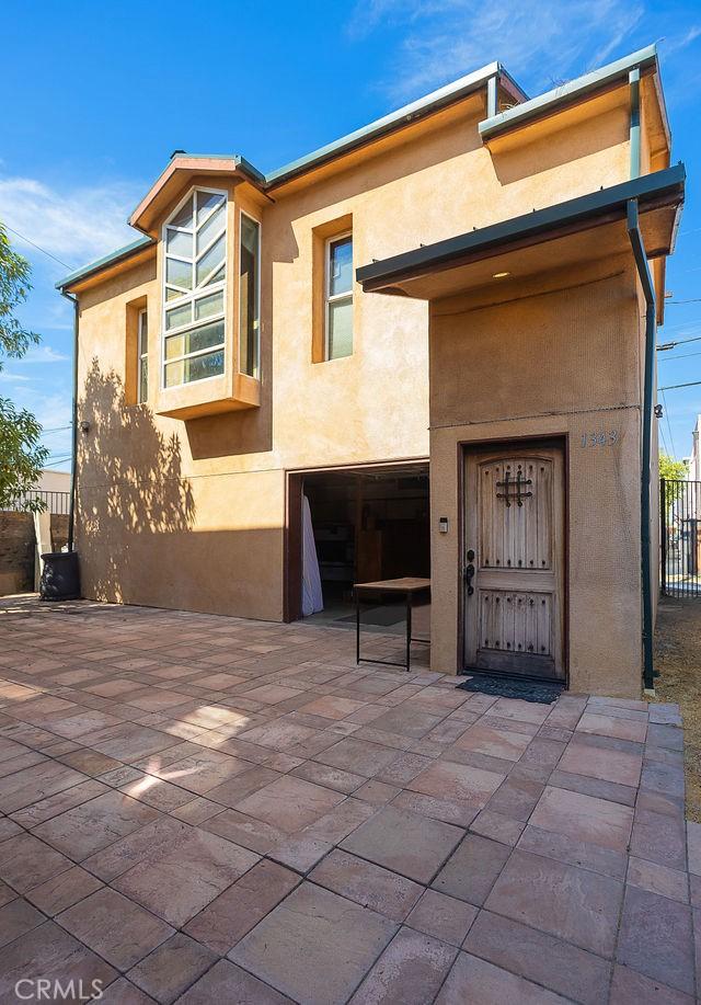 view of front of house with fence, stucco siding, a patio, and a garage