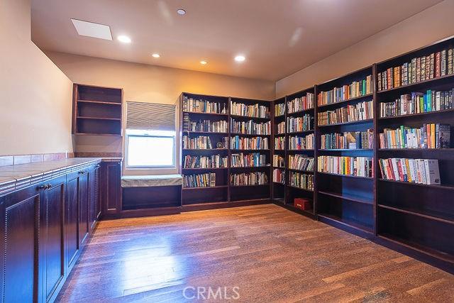 unfurnished office featuring recessed lighting, bookshelves, and wood finished floors