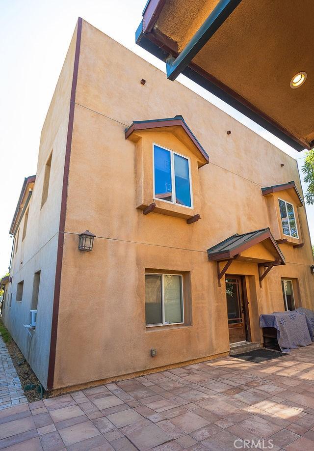 rear view of house featuring stucco siding and a patio area