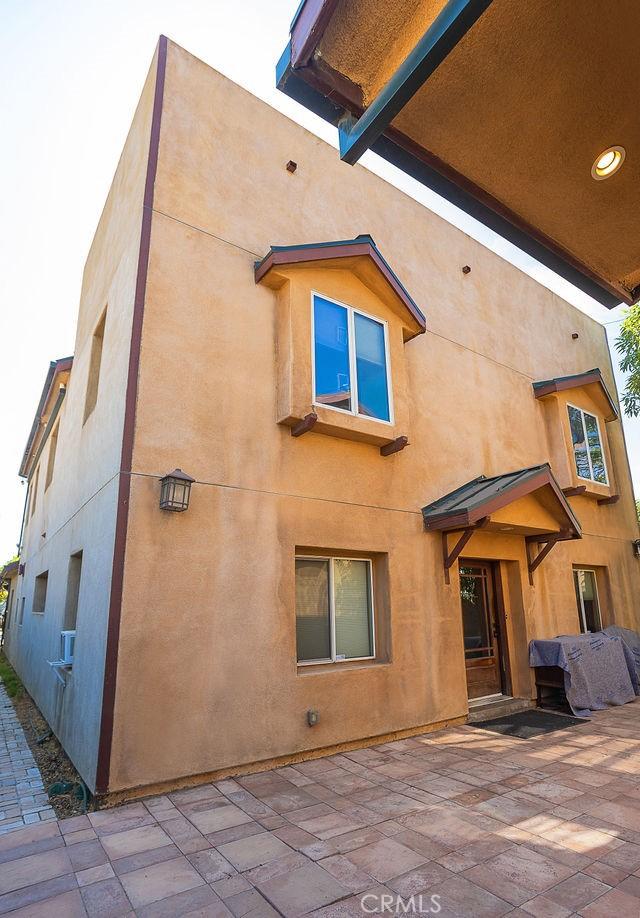 back of property with stucco siding and a patio