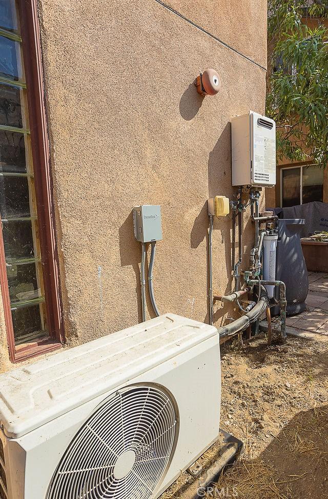 exterior details with stucco siding and ac unit