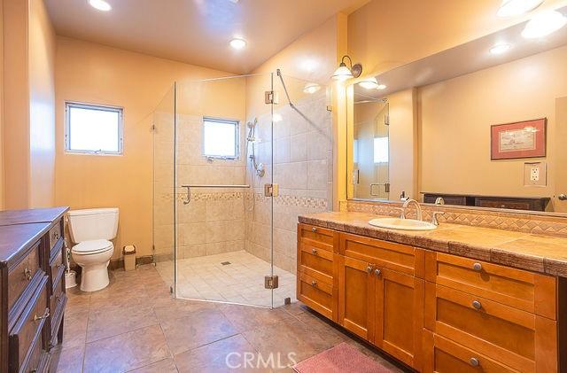 bathroom with a shower stall, toilet, recessed lighting, tile patterned floors, and vanity