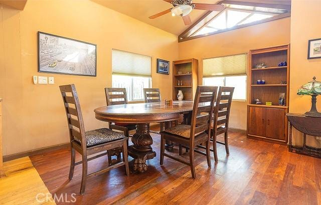 dining room featuring high vaulted ceiling, wood finished floors, a ceiling fan, and plenty of natural light