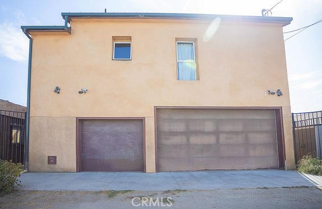 exterior space featuring fence, stucco siding, and a garage