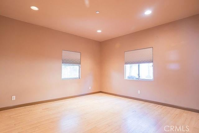 spare room with light wood-style flooring, baseboards, recessed lighting, and a wealth of natural light