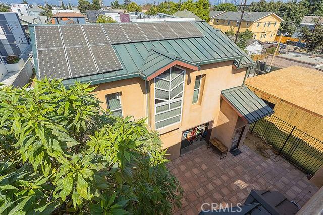 view of home's exterior with a standing seam roof, solar panels, stucco siding, and metal roof