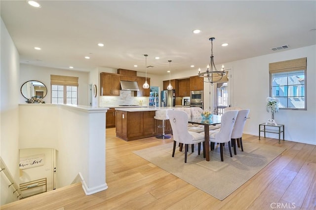 dining room with a notable chandelier and light hardwood / wood-style floors