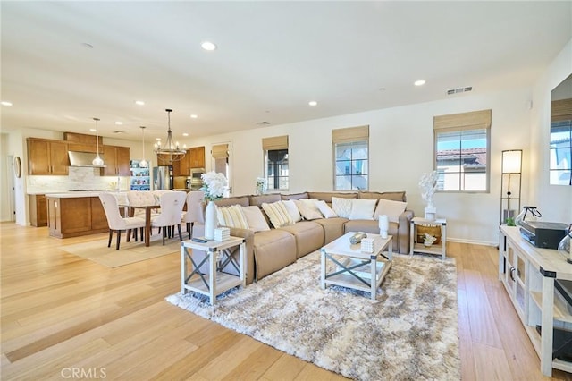 living room featuring an inviting chandelier and light hardwood / wood-style floors