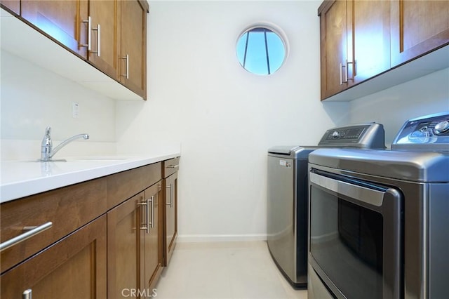 clothes washing area with sink, cabinets, and washing machine and clothes dryer