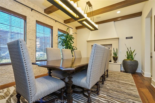 dining room featuring dark wood-type flooring and beamed ceiling