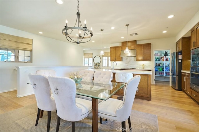 dining area featuring an inviting chandelier and light hardwood / wood-style floors